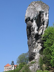 The Cudgel of Hercules, a tall limestone rock in Poland (Pieskowa Skala Castle in the background) Maczuga Herkulesa (background Castle Pieskowa Skala).jpg