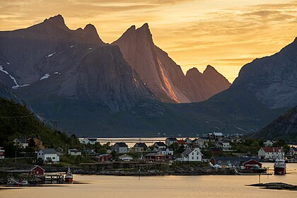 Půlnočním sluncem osvětlené štíty hor na norském ostrově Moskenesøy v Lofotech