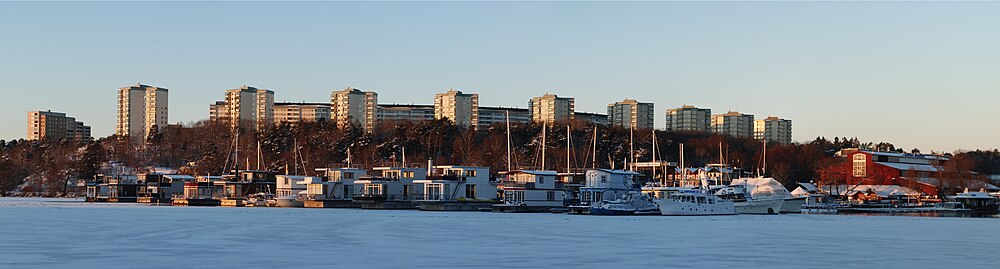 Bild över bostadsområdet Västra skogen (arkitekt Kaj Sucksdorff 1967-70) i Huvudsta med Ulvsundasjön och Pampas Marina i förgrunden, vy från Stadshagen.