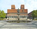 Rådhusplassen med rådhuset bak og skulpturparken på «Synken» foran. Statuene i parken er av Emil Lie og Per Hurum. Foto: 2014