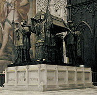 Columbus's tomb in Seville Cathedral. It is borne by four statues of kings representing the Kingdoms of Castile, Leon, Aragon, and Navarre.