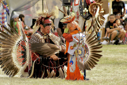 An adult and a child in traditional regalia during a pow-wow at the Manawan Atikamekw Community, picture uploaded to Wikimedia Commons during the Nitaskinan in pictures contest