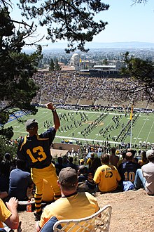 Fans atop Tightwad Hill watch the Cal Band, with views of the stadium and the San Francisco Bay. Cal Football From Tightwad Hill - Flickr - Joe Parks.jpg