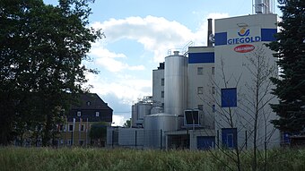 Fabrikgebäude mit Silos und großer Firmenaufschrift