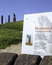 Plaquette ter herdenking van de plaatsing van een nieuw beeld in 2013 waarop benadrukt wordt dat het nieuwe beeld van kunststof is