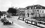 Motorwagen 77 op lijn 2 van de Gemeentetram Utrecht (GTU) en een tramstel van de NBM (motorwagen 5 en bijwagen 53) op het Stationsplein te Utrecht met rechts het Hotel Du Commerce (Stationsplein 12); circa 1927. Collectie van het Utrechts Archief.