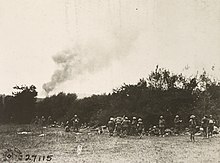 Scene at advanced first-aid station of the 325th Infantry Regiment, 82nd Division. The wounded arrive on stretchers while in the background a German munitions dump is burning at Marcq, American Red Cross. North of Fleville, Ardennes, France, October 1918. 111-SC-27115 - NARA - 55213734 (cropped) (cropped).jpg