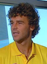 A brown-haired man in a yellow polo shirt