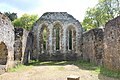 grey stone walls leading to an end wall with three tall window openings (from Surrey)