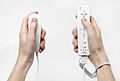 Wii-Fernbedienung, die die Bewegung mittels Beschleunigungssensoren erfasst und mit Hilfe der Sensorleiste die Position übermittelt