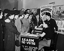 Women surrounded by posters in English and Yiddish supporting Franklin D. Roosevelt, Herbert H. Lehman, and the American Labor Party teach other women how to vote, 1936. Women voter outreach 1935 English Yiddish.jpg