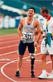 Australian athlete Don Elgin receives support from an official at the completion of one of the events in the pentathlon at the 1996 Atlanta Paralympic Games