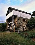 The structure originally consisted of two storeys measuring 5 m by 4 m internally. A third storey of brick was somewhat smaller and was probably added later. The roof was of slate from North Wales, brought out to Port Elizabeth as ships' ballast. This wool mill was built in 1821 by Samuel Bradshaw, an 1820 Settler. It played an important role in the history of the wool industry in South Africa. The remains of the first wool mill to be built in the Eastern Province and probably the first in South Africa. Type of site: Mill.