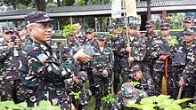 BGen Johnny Macanas AFP, AFP Deputy J-9, demonstrates to members of the 105th TASG the proper way of planting and growing trees.