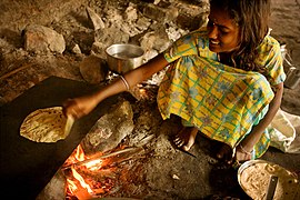 A girl baking chapatis in the traditional way.