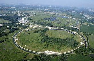 The Tevatron (background circle), a synchrotron collider type particle accelerator at Fermi National Accelerator Laboratory (Fermilab), Batavia, Illinois, USA. Shut down in 2011, until 2007 it was the most powerful particle accelerator in the world, accelerating protons to an energy of over 1 TeV (tera electron volts). Beams of protons and antiprotons, circulating in opposite directions in the rear ring, collided at two magnetically induced intersection points. Fermilab.jpg