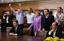 Prime Minister David Cameron of the United Kingdom, President Barack Obama, Chancellor Angela Merkel of Germany, José Manuel Barroso, President of the European Commission, President François Hollande of France and others react emotionally while watching the overtime shootout of the Chelsea vs. Bayern Munich Champions League final, in the Laurel Cabin conference room during the G8 Summit at Camp David, Maryland, May 19, 2012. Cameron raises his arms triumphantly as the Chelsea team wins their first Champions League title in the overtime shootout.