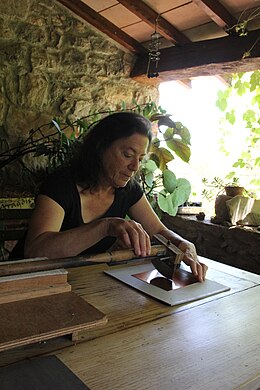 Judith Rothchild perçant une plaque de cuivre.