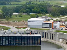 Muon g-2 building (white and orange) which hosts the magnet Muon g-2 building at Fermilab.jpg