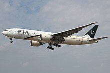 Aircraft landing approach. Front quarter view of twin-engine jet in flight with flaps and landing gear extended.