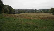 Photo from the top of a hill looking at rising ground in the distance