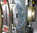 Die roten Pfeile markieren das Strahlaustrittsfenster der Röhre eines 16-Zeilen CTs. Rechts im Bild ist der Röhrentank zu sehen; in den oben und unten angeschlossenen Rohrleitungen läuft die Kühlflüssigkeit zur Kühlung der Röhre.
