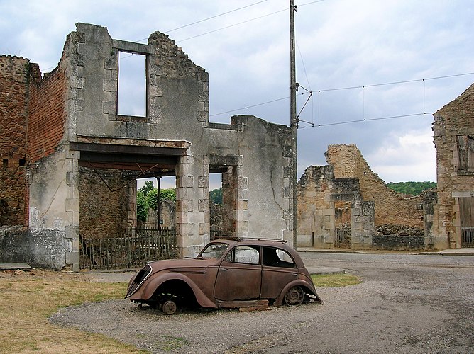Автомобиль и развалины зданий в деревне Орадур-сюр-Глан