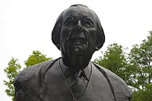 Photo en couleur d'une sculpture de couleur noire de buste d'un homme