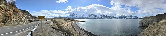 Sagaveien (fylkesvei 876) går inn i Kvernsundtunnelen på Bjarkøysida. Den 3,2 km lange undersjøiske tunnelen er del av Bjarkøyforbindelsen mellom Grytøya, Bjarkøya og Sandsøya og ble åpnet 15. desember 2018. Bildet viser utsyn over Kvernsundet med snøkledte fjell på Grytøya bak, og avkjøring til Austnes. Fortegnet panorama: 2019