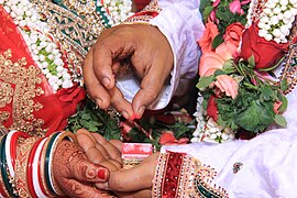 Bridegroom placing Sindoor on bride's forehead, as part of a Hindu wedding in India