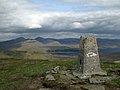 Die Trigonometrische Säule auf dem Gipfel des Fionn Bheinn, im Hintergrund Loch Fannich und die Hauptkette der Fannichs mit dem Sgùrr nan Clach Geala (ganz links) und der Pyramide des Sgùrr Mòr (links)