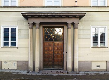 Entré till Atlasmuren 16 i 1920-talsklassicism (1928) och Torphagsvägen 20 i funktionalismens stilriktning (1935).