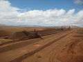 Un stacker en train de constituer un tas homogénéisation dans une mine. En arrière-plan, une excavatrice à godets en attente.