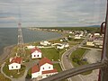 Vue vers l'est du sommet du phare de la Pointe-au-Père. La station du phare, la maison du gardien et d'autres sites d'exposition peuvent être vus en bas de l'image, sur les berges du Fleuve Saint-Laurent.