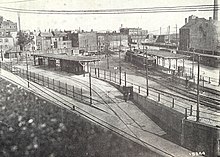 Overhead view of a surface streetcar terminal with wooden canopies in an urban square