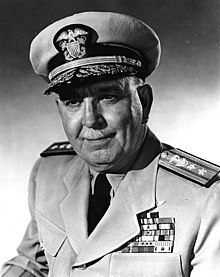 Older Caucasian man with small white mustache wearing U.S. Navy Service Dress Khaki uniform and hat