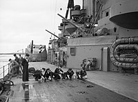 Matrozen schrobben het dek van het Britse oorlogsschip Rodney in de Tweede Wereldoorlog