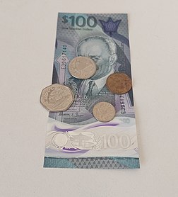 A Barbadian 100 Dollar bill with various Barbadian coins on it.jpg