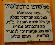 A wall sign advising attendants of a Jewish synagogue on what to do during prayer.