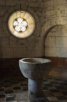 Oculus quintilobé éclairant les fonts baptismaux dans une absidiole de l'église Sainte-Blaise, à Lacommande, dans le département français des Pyrénées-Atlantiques. (définition réelle 2 075 × 3 125)