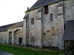 Façade ouest de la ferme de Fourcheret, avec l'ancienne porterie (à gauche) et un pan de mur d'origine du logis, avec trois contreforts. Plus à droite, les contreforts ont disparu.
