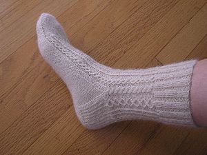 A hand knitted white lace sock award for gener...
