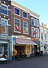 Winkel/woonhuis met drie bouwlagen, lijstgevel, schilddak en Amsterdamse School invloeden (Gouda-Centrum)