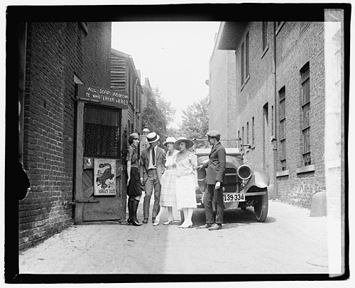 Several patrons and a flapper await the opening of the Krazy Kat Klub, a speakeasy in 1921