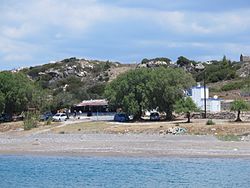 Blick von der Mole von Plimmyri auf den Strand und eine Taverne