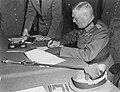 Image 5 German Instrument of Surrender Photograph cr: Lt. Moore; restored by Adam Cuerden The German Instrument of Surrender was the legal document that effected the termination of the Nazi regime and ended World War II in Europe. A July 1944 draft version had also included the surrender of the German government, but this was changed due to concern that there might be no functional German government that could surrender; instead, the document stated that it could be "superseded by any general instrument of surrender imposed by, or on behalf of the United Nations", which was done the next month. This photograph shows Field Marshal Wilhelm Keitel signing the German Instrument of Surrender in Berlin. The first surrender document was signed on 7 May 1945 in Reims by General Alfred Jodl, but this version was not recognized by the Soviet High Command and a revised version was required. Prepared in three languages on 8 May, it was not ready for signing in Berlin until after midnight; consequently, the physical signing was delayed until nearly 1:00 a.m. on 9 May, and backdated to 8 May to be consistent with the Reims agreement and public announcements of the surrender already made by Western leaders.
