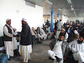Viroj portantaj perahan-tunban-on, formo de ŝalvarĉemizo en Kabula flughaveno, en Afganio.