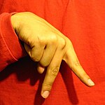 The "K" handshape produced with the the back of the hand facing the camera