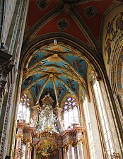 Photographie d'un chœur d'église richement orné et éclairé par de vastes fenêtres.