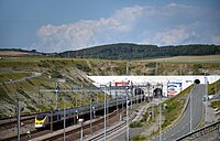 Since 1994, the Channel Tunnel (French entrance pictured) has provided a direct rail link between the United Kingdom and France. TGV TMST 3011-2 - Sortie Tunnel sous la Manche a Coquelles.jpg